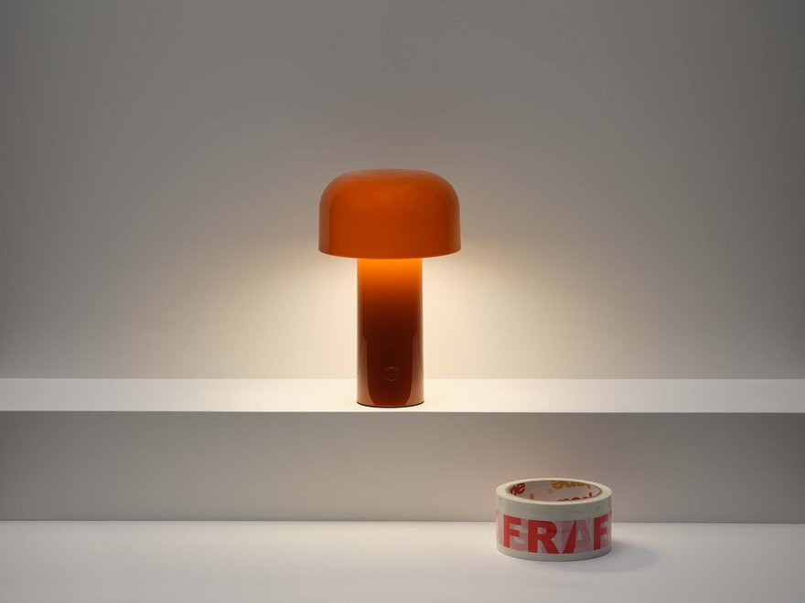 Minimalist scene with a glowing orange mushroom-shaped lamp and a roll of tape labeled "FRAGILE" on a white shelf.