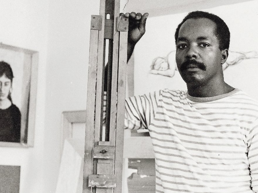 A young man stands by an artist's easel