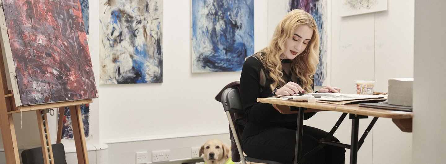 Kimberley Burrows in her studio with Tammy the guide dog